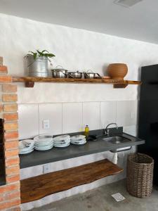 a kitchen with a counter with dishes and a sink at Casa di Maria flats in Icaraí