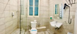 a bathroom with a toilet and a sink at The Maltese Sun in Sliema