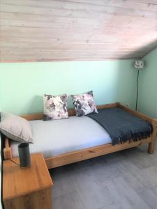 a wooden bed with pillows on it in a room at Villa Luger 2 Dachgeschoss in Rogoznica