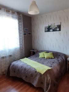 a bedroom with a large bed with yellow pillows at Tulipe24 in Savigné-lʼÉvêque