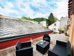 un patio con 2 sillas y una mesa en el techo en Mosel-Loft, en Bernkastel-Kues