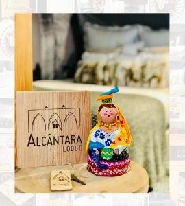 a small figurine sitting on a table next to a sign at Alcântara Lodge in Lisbon