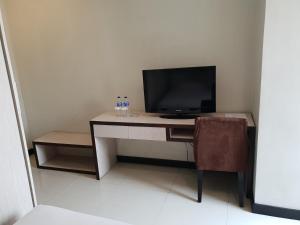 uma secretária com uma televisão e uma cadeira num quarto em N3 Zainul Arifin Hotel em Jakarta