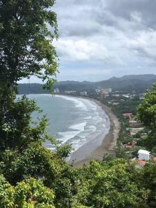 een uitzicht op een strand met de oceaan bij Family condo in Jaco, jacuzzis, pools and terrace in Jacó