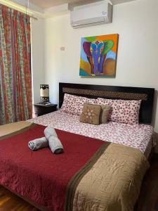 een slaapkamer met een groot bed en een rode deken bij Family condo in Jaco, jacuzzis, pools and terrace in Jacó