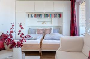 1 dormitorio con cama con estante para libros y sofá en Step8_18, en Westerland