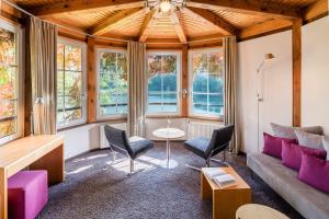 a living room with a couch and chairs and windows at Romantischer Seegasthof & Hotel Altes Zollhaus in Feldberg