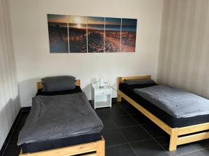 dwa łóżka w pokoju z obrazem na ścianie w obiekcie Ferienwohnung Staufenberg 2 w mieście Staufenberg
