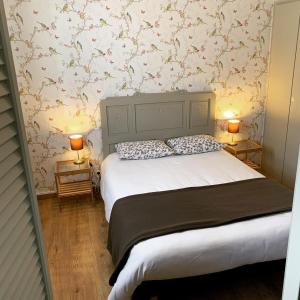 LesperonにあるHôtel et RESTAURANT traditionnel L' Escalandesのベッドルーム1室(大型ベッド1台、ランプ2つ付)
