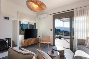 een woonkamer met een bank en een tv bij Villa Elia in Maroulás