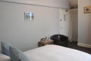 ボウネス・オン・ウィンダミアにあるヘーゼルデーン ゲスト ハウスのベッドと椅子付きのホテルルーム