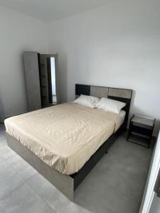 Ce lit se trouve dans une chambre dotée d'un mur blanc. dans l'établissement Modern Flat in Flic en Flac-walk to the beach, à Flic-en-Flac