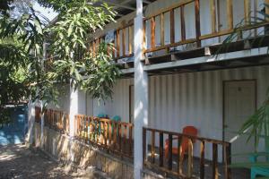 einen Balkon eines Hauses mit einem Baum in der Unterkunft Kali Hostal in La Libertad