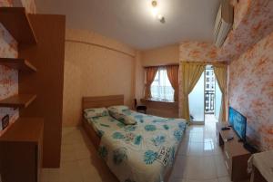 Un pequeño dormitorio con una cama y una escalera en Apartemen Margonda Residence 3, en Kemirimuka Dua