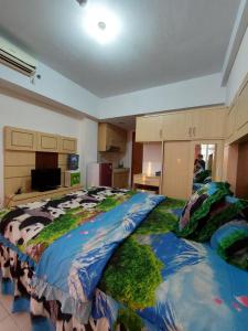 1 dormitorio grande con 1 cama grande con edredón de vaca en Apartemen Margonda Residence 3, en Kemirimuka Dua
