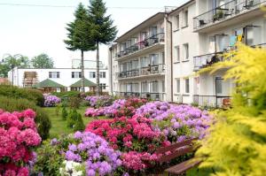 a garden of flowers in front of a building at Apartament ARKA in Jarosławiec