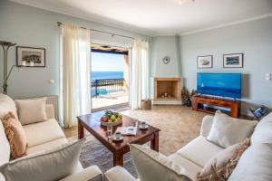 a living room with a couch and a table and a television at Villa Tramonto Minies in Minia