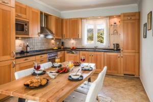 a large kitchen with a wooden table and chairs at Villa Tramonto Minies in Minia