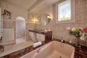uma casa de banho com uma banheira, um lavatório e um WC. em IMMOGROOM- Top of villa 200m2 - Garden - Pool - Sea view - Parking - Wifi em Vallauris