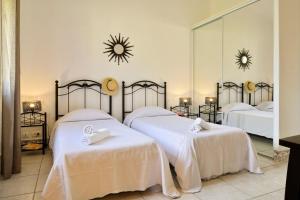 a bedroom with two beds and a large mirror at U Paesolu in Sainte-Lucie de Porto-Vecchio