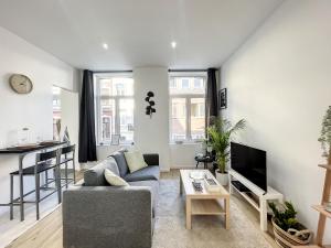 een woonkamer met een bank en een tafel bij Cosy Apartment Brussels - Palais Royal in Brussel
