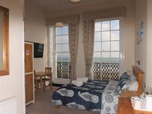 a bedroom with a bed with a view of the ocean at The Edenhurst Guesthouse in Weymouth