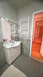 a bathroom with a sink and a mirror and a door at Apartments City On The Palm in Tbilisi City