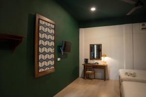 a room with a green wall with a table and a mirror at Room V Jalan Sultanah Near Bus Stop Batu Pahat in Batu Pahat