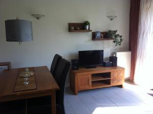 a living room with a dining table and a television at Beachhouse Tossens in Tossens