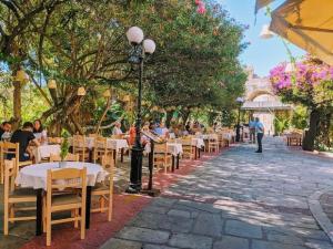 a restaurant with tables and chairs on a sidewalk at Zoes Apartment Kos Town in Kos Town