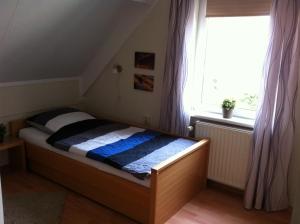 a small bed in a room with a window at Beachhouse Tossens in Tossens