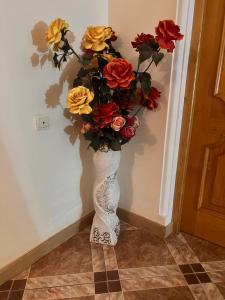 a vase with a bouquet of flowers on a wall at Apartments City On The Palm in Tbilisi City