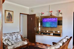 a living room with a couch and a flat screen tv at Casa Fiorelli in Cunha