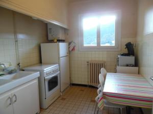 a small kitchen with a table and a white refrigerator at Appartement Amélie-les-Bains-Palalda, 2 pièces, 2 personnes - FR-1-703-116 in Amélie-les-Bains-Palalda