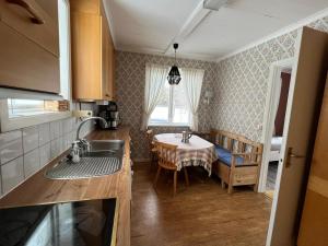 a kitchen with a sink and a table with a tablecloth at High Noon Westernranch Holidayhouse in Ljusdal