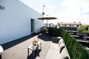 a balcony with a table and an umbrella at 4 Mares Apartamentos A in Loredo