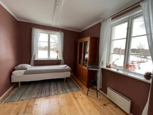 a bedroom with a bed and two windows at High Noon Westernranch Holidayhouse in Ljusdal