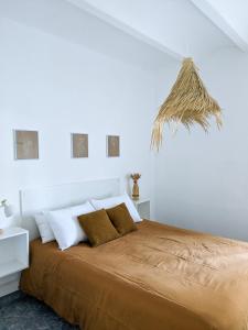 a white bedroom with a large bed with white pillows at Masia Rosalia in L'Aldea