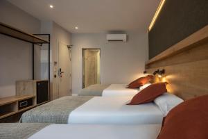 1 dormitorio con 2 camas y TV. en Fontanella By BCN URBAN Rooms, en Barcelona
