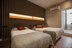 two beds in a room with black stripes at Fontanella By BCN URBAN Rooms in Barcelona +17 photos