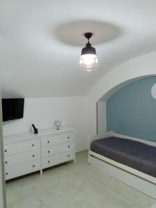 Schlafzimmer mit einem Bett, einem TV und einer Kommode in der Unterkunft casa italia in Neapel