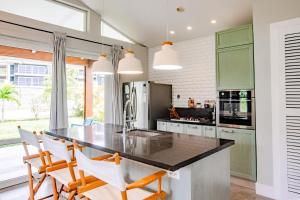 a kitchen with green cabinets and a black counter top at Villa #6 - Blue Venao, Playa Venao in Playa Venao