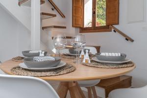 una mesa de comedor con platos y copas de vino en tuGuest casa del mirador, en Granada