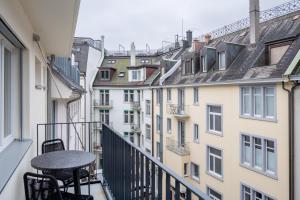 a balcony with a table and chairs and buildings at numa I Craft Apartments in Zürich