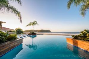 a swimming pool with the ocean in the background at Villa #6 - Blue Venao, Playa Venao in Playa Venao