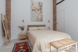 1 dormitorio con 1 cama y una pintura en la pared en tuGuest casa del mirador, en Granada