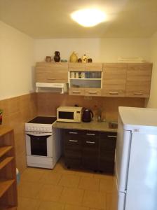 a kitchen with a stove and a microwave at Chatová osada U Jaryna in Doksy