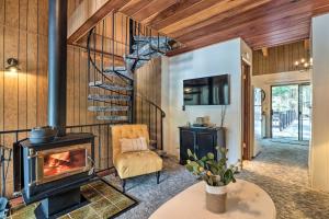 a living room with a fireplace and a chair at Pinecrest Retreat with Fireplace! in Pinecrest