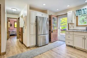 a kitchen with white cabinets and a stainless steel refrigerator at Pet-Friendly Gilford Home 3 Mi to Gunstock and Lake in Gilford