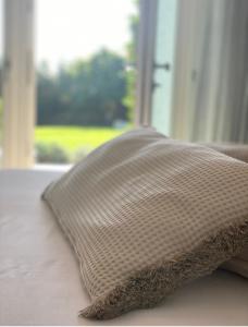 uma almofada sentada numa cama em frente a uma janela em B&B Panorama Cinque em Salò